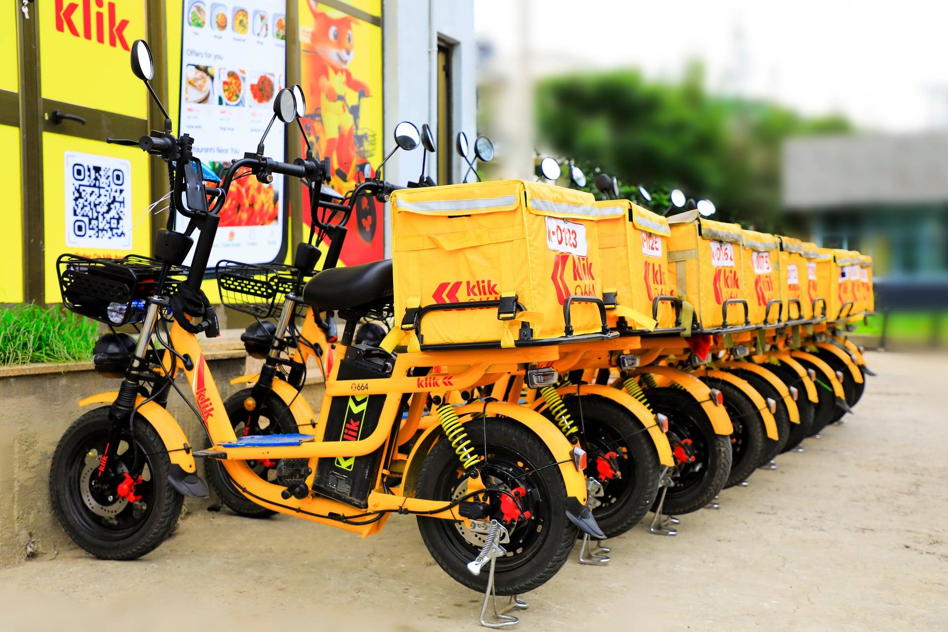 A row of klik electric bikes parked outside a station at late-afternoon light in Addis Ababa